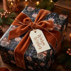 Luxury Christmas wrapping paper with pinecone print and rust velvet ribbon by Wrapped Studios.