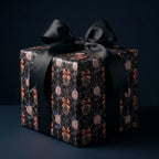 Luxury Christmas gift wrap with a dark vintage ornament print and black satin bow by Wrapped Studios.