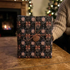 Luxury Christmas wrapping paper with vintage ornament pattern and bronze JOY tag by Wrapped Studios.