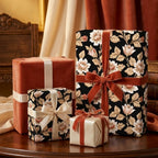 Luxury black floral wrapping paper with rust velvet ribbons on gift boxes by Wrapped Studios.