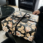 Vintage black floral wrapping paper with a velvet bow on a luxury gift box by Wrapped Studios.