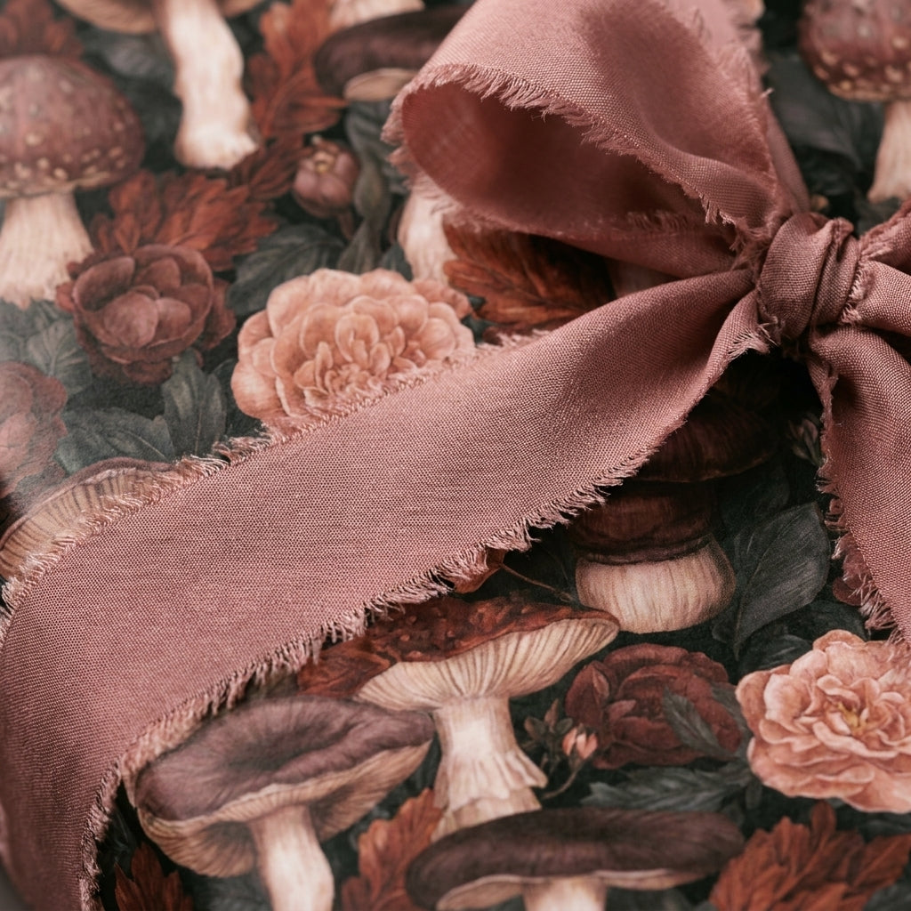 Vintage mushroom botanical wrapping paper tied with a dusty rose ribbon, by Wrapped Studios.