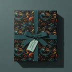 Dragon-themed gift box with artistic patterned wrapping paper and teal ribbon.