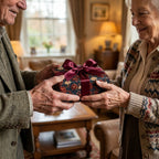 Luxury vintage floral wrapping paper with a burgundy bow on a gift held by a senior couple, Wrapped Studios.