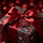 Luxury vintage floral wrapping paper in navy and red with a satin bow on a Christmas gift by Wrapped Studios.
