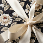 Luxury black and cream floral wrapping paper with a satin ribbon bow by Wrapped Studios.