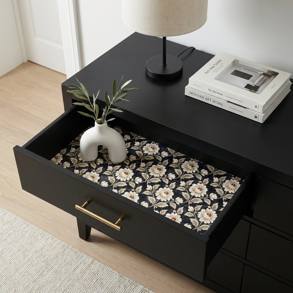 Vintage floral wrapping paper used as elegant drawer liner in a black dresser. Wrapped Studios.