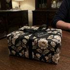 Luxury vintage floral wrapping paper with black ribbon on a gift box, by Wrapped Studios.