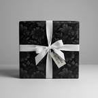 Elegant gift wrapped in black floral wrapping paper with white satin ribbon and bow.