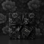 Elegant gift wrapped in black floral wrapping paper with a satin ribbon and "Exclusively Yours" tag.