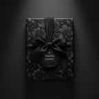 Elegant floral wrapping paper in black, tied with a satin bow and circular tag saying "A Timeless Gesture".