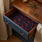 Dark floral wrapping paper used as a vintage drawer liner in a blue wooden dresser, by Wrapped Studios.