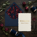 Moody burgundy floral wedding invitation with navy envelope and blue velvet ribbon by Wrapped Studios.
