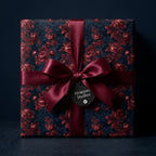 Luxury dark floral wrapping paper with a burgundy satin bow on a gift box by Wrapped Studios.