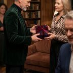 Couple exchanging a holiday gift in luxury floral wrapping paper with a burgundy velvet ribbon by Wrapped Studios.