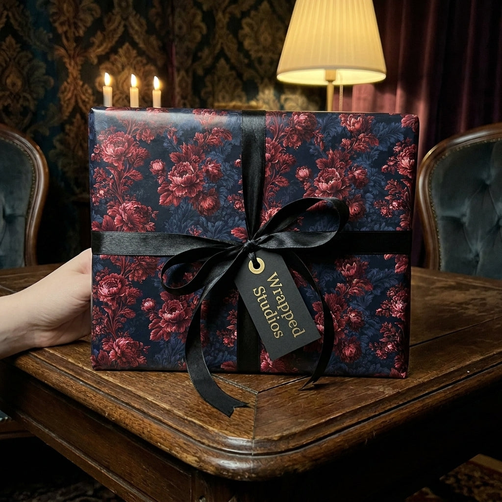Luxury moody floral wrapping paper with a black ribbon and tag by Wrapped Studios.