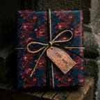 Luxury dark floral wrapping paper with a copper For Him tag and twine bow by Wrapped Studios.