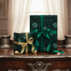 Elegant gifts wrapped in dark floral wrapping paper with emerald and gold ribbon bows.