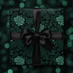 Elegant gift wrapped in dark floral wrapping paper with a black satin ribbon and bow.