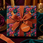 Luxury moody floral wrapping paper with an orange ribbon and Celebrate tag by Wrapped Studios.