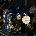Luxury dark floral wrapping paper with navy velvet bow and 'For You' gift tag by Wrapped Studios.