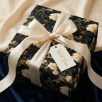Luxury dark floral wrapping paper with cream satin ribbon and gift tag by Wrapped Studios.