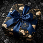 Luxury dark floral wrapping paper with a navy blue satin bow and gift tag from Wrapped Studios.