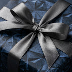 Luxury navy blue geometric wrapping paper with a silver satin ribbon bow by Wrapped Studios.