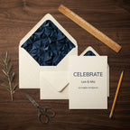 Elegant navy blue geometric wedding invitation and envelope liner set on dark wood, by Wrapped Studios.
