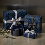 Luxury navy blue geometric wrapping paper with satin ribbons on gift boxes by Wrapped Studios.