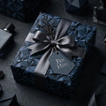 Navy geometric wrapping paper for him with grey satin ribbon and 'For Him' tag by Wrapped Studios.