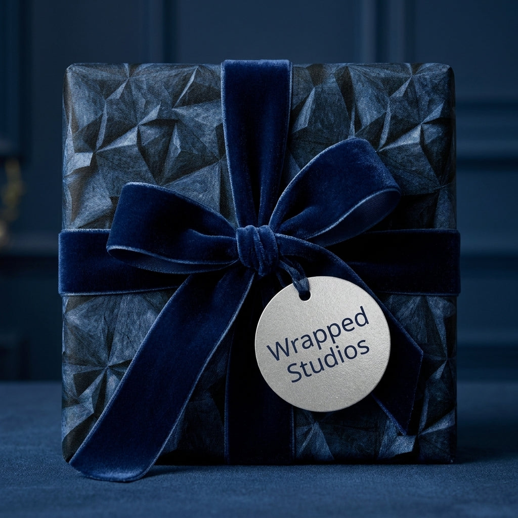 Luxury navy blue geometric wrapping paper with a velvet bow and silver gift tag by Wrapped Studios.