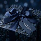 Luxury navy blue geometric wrapping paper with a satin bow and "With Love" gift tag by Wrapped Studios.