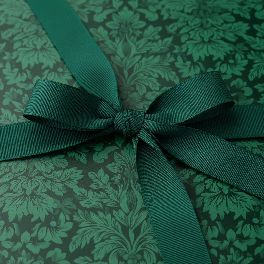 Elegant gift wrapped in dark green floral wrapping paper with a matching grosgrain ribbon bow.
