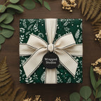 Dark green floral wrapping paper with natural ribbon and foliage.
