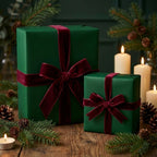 Elegant emerald green Christmas gift wrap with burgundy velvet ribbon on wood table.