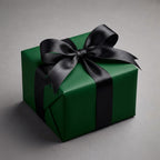 Emerald green gift wrap with black satin ribbon bow on a square present box.