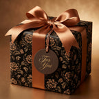 Luxury black and gold floral wrapping paper with a bronze satin ribbon on a gift box by Wrapped Studios.