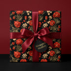 Luxury dark floral gift wrap with red flowers and a burgundy satin bow by Wrapped Studios.