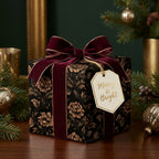Luxury floral Christmas gift wrap by Wrapped Studios, with a burgundy velvet bow and Merry & Bright tag.