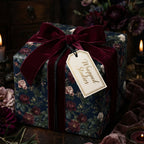 Moody floral wrapping paper by Wrapped Studios on a gift box tied with a luxury burgundy velvet ribbon.