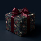 Luxury dark floral wrapping paper with a burgundy satin bow on a gift box by Wrapped Studios.
