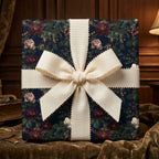 Moody dark floral wrapping paper with a cream ribbon bow, luxury gift wrap by Wrapped Studios.