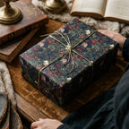 Vintage dark floral wrapping paper with gold string on a gift box by Wrapped Studios.
