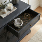 Moody pinecone Christmas gift wrap used as drawer liner in a modern black dresser by Wrapped Studios.