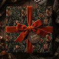 Luxury Christmas wrapping paper with a rustic pinecone pattern and orange velvet bow by Wrapped Studios.