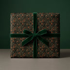 Luxury forest Christmas wrapping paper with a green velvet bow by Wrapped Studios.
