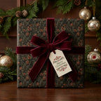 Luxury forest Christmas wrapping paper with a burgundy velvet bow and tag by Wrapped Studios.