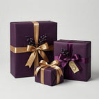 Elegant dark purple gift boxes wrapped with gold and plum satin ribbon for birthday or special occasion.