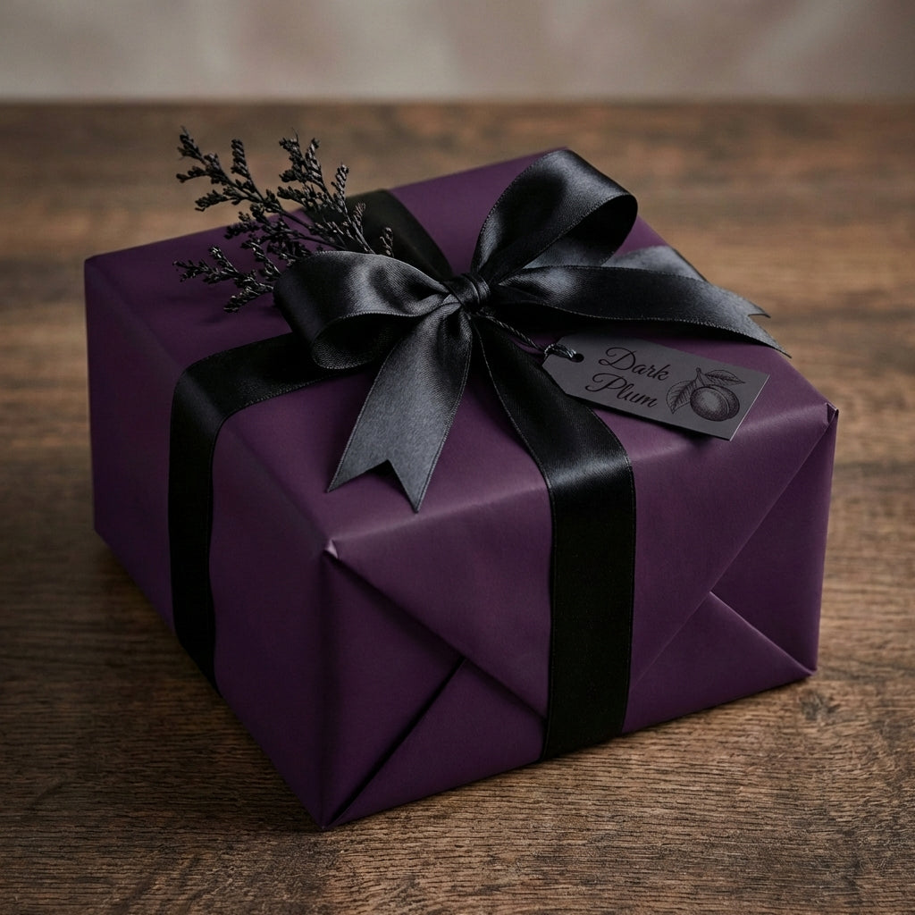 Elegant plum wrapping paper with black satin ribbon and bow, perfect for luxury gift giving.
